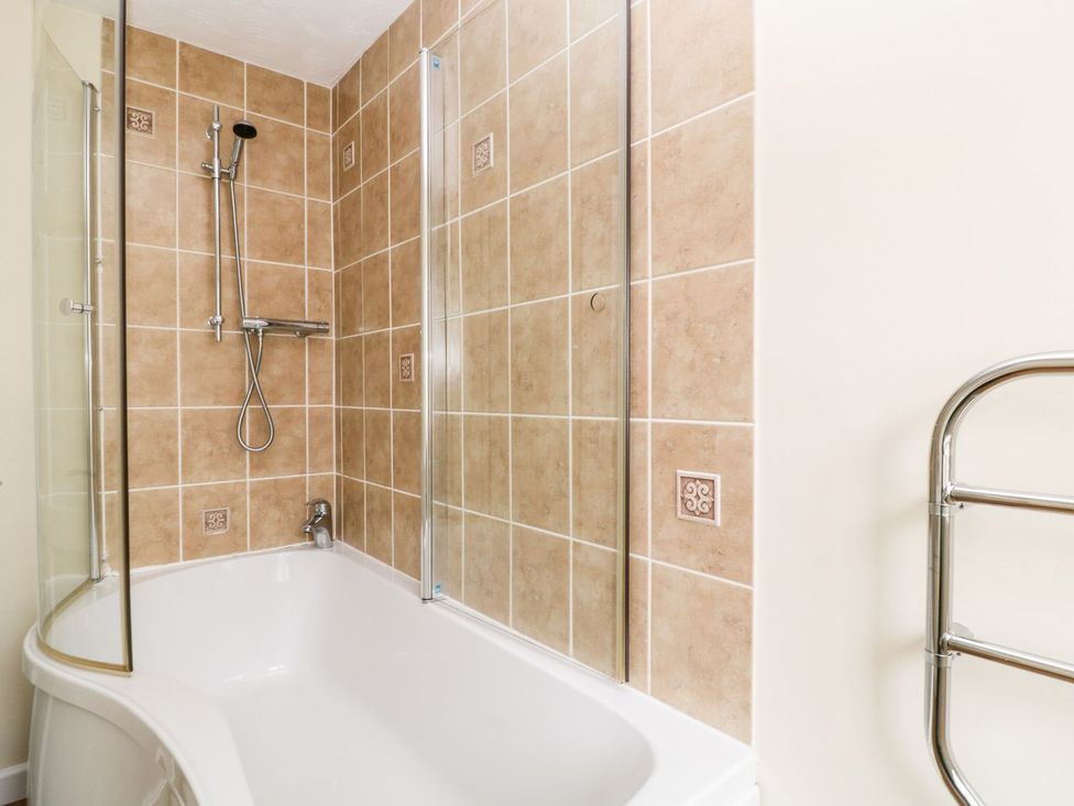 A bathroom with a bathtub and shower at Honeysuckle in Tavistock