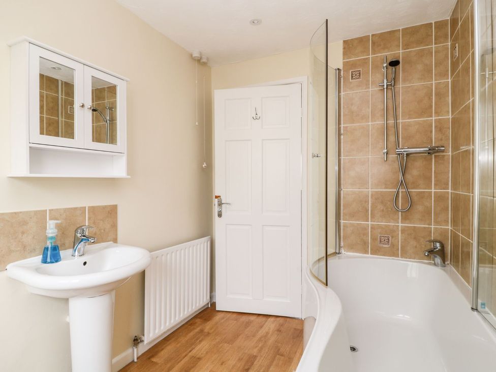 A bathroom with a sink and bathtub at Honeysuckle in Tavistock