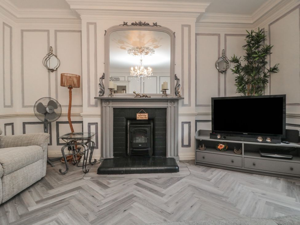 A living room with a fireplace and television at The Hyding Place in Whitby