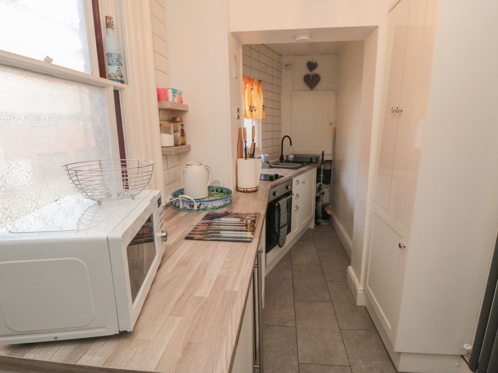 A kitchen with a microwave and sink at The Hyding Place in Whitby
