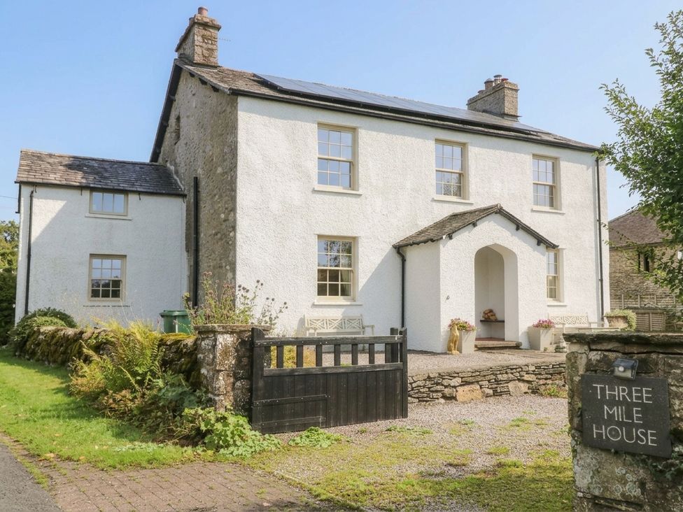 A house with a front pathway and gate at Three Mile House in Carnforth
