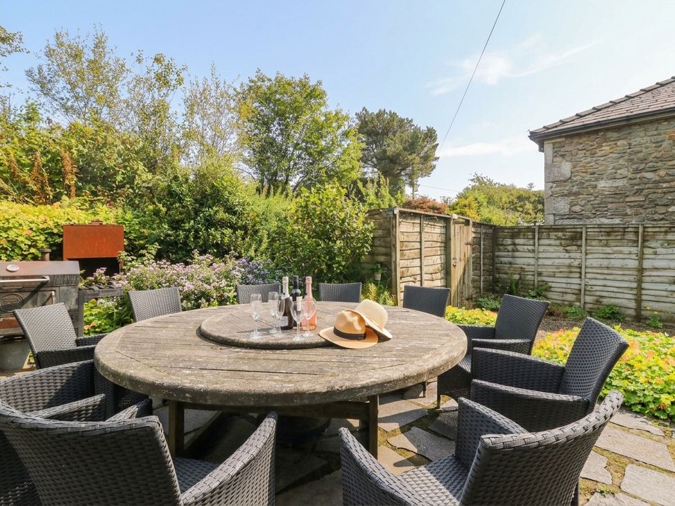 A garden with a round table and chairs at Three Mile House in Carnforth
