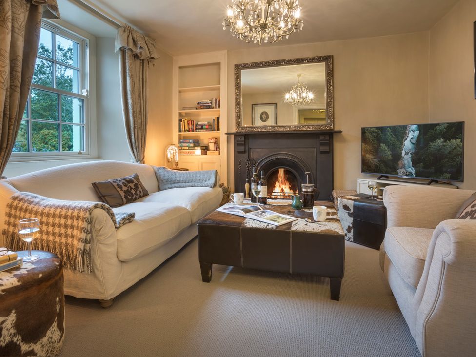 A living room with a fireplace and sofa at Three Mile House in Carnforth