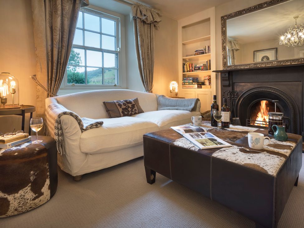 A living room with a fireplace and a coffee table at Three Mile House in Carnforth