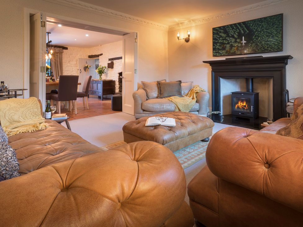 A living room with sofas and an ottoman at Three Mile House in Carnforth