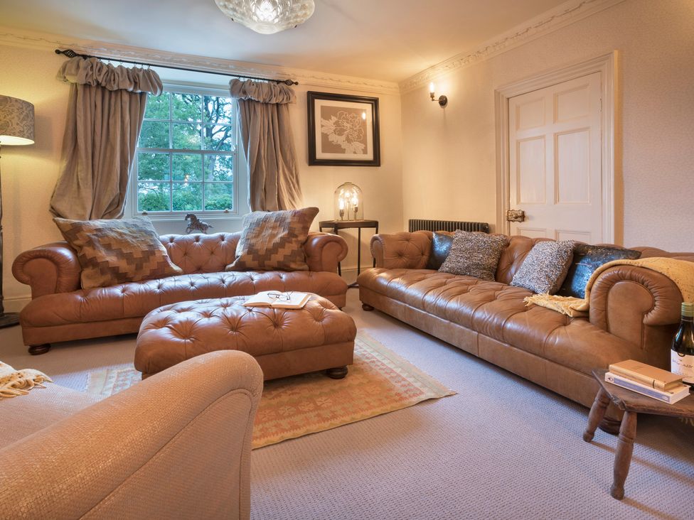 A living room with sofas and a coffee table at Three Mile House in Carnforth