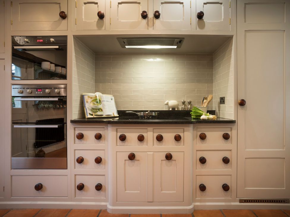 A kitchen with oven, countertop, sink, and storage cabinets at Three Mile House in Carnforth