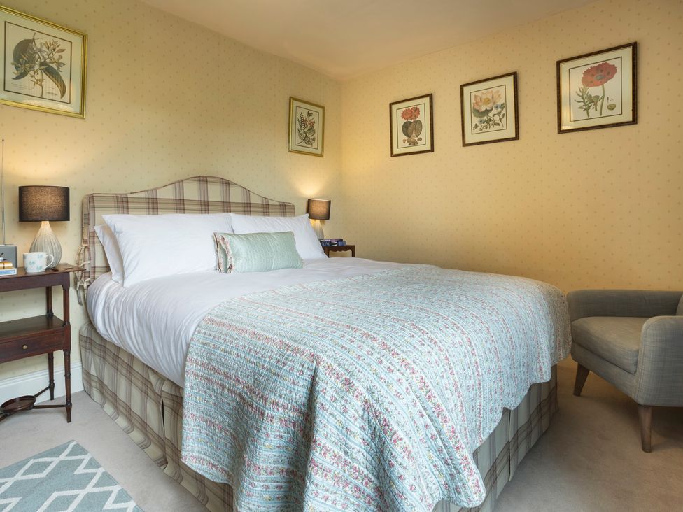 A bedroom with a bed and nightstand at Three Mile House in Carnforth