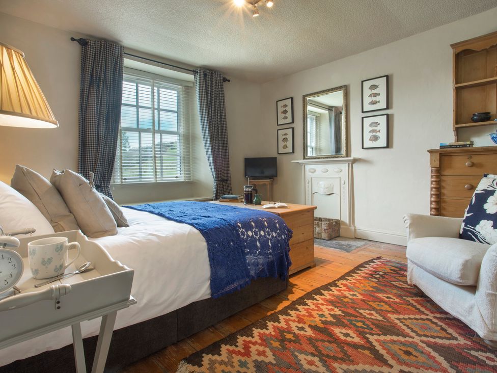 A bedroom with a bed and mirror at Three Mile House in Carnforth