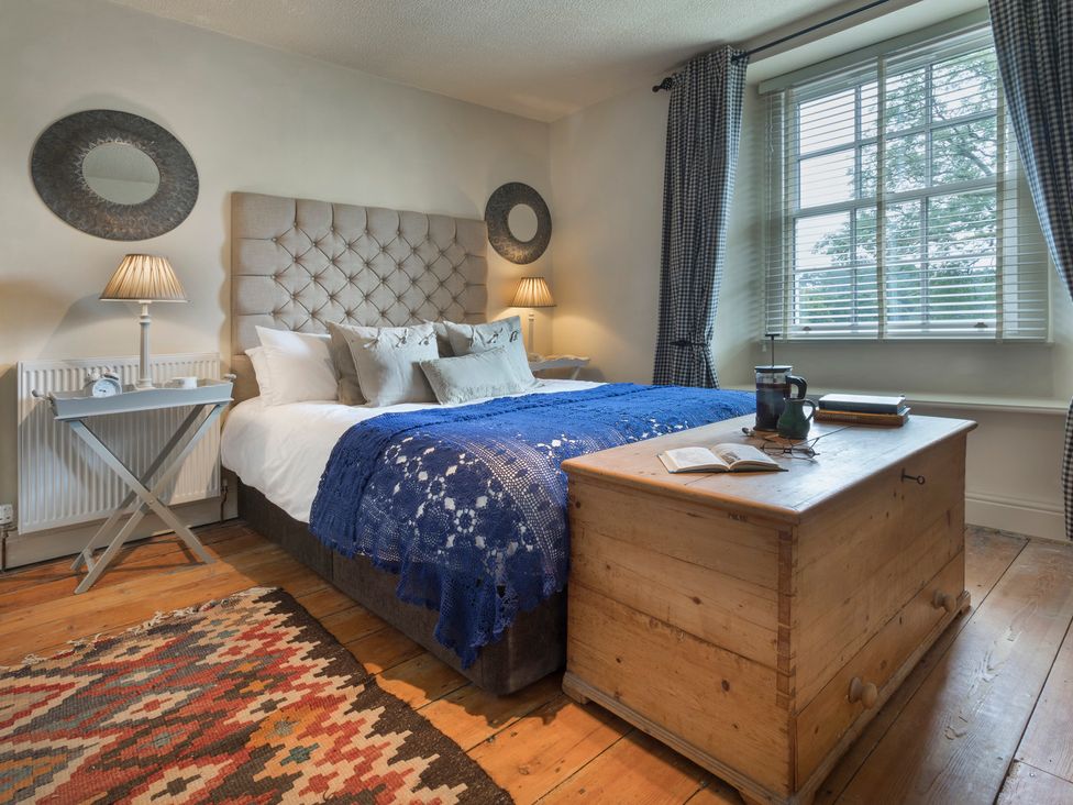 A bedroom with a bed and bedside table at Three Mile House in Carnforth