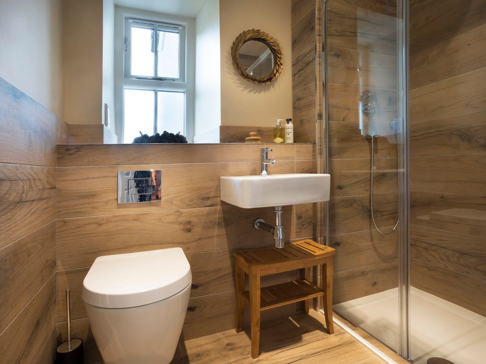 A bathroom with a shower, toilet, and sink at Three Mile House in Carnforth