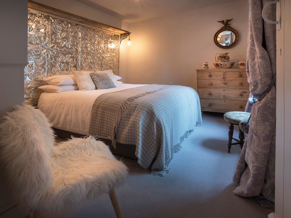 A bedroom with a bed and dresser at Three Mile House in Carnforth