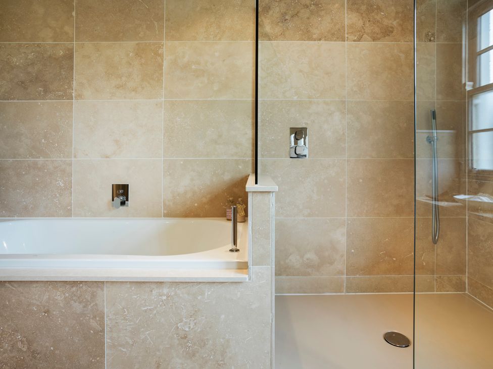 A bathroom with a bathtub and shower at Three Mile House in Carnforth