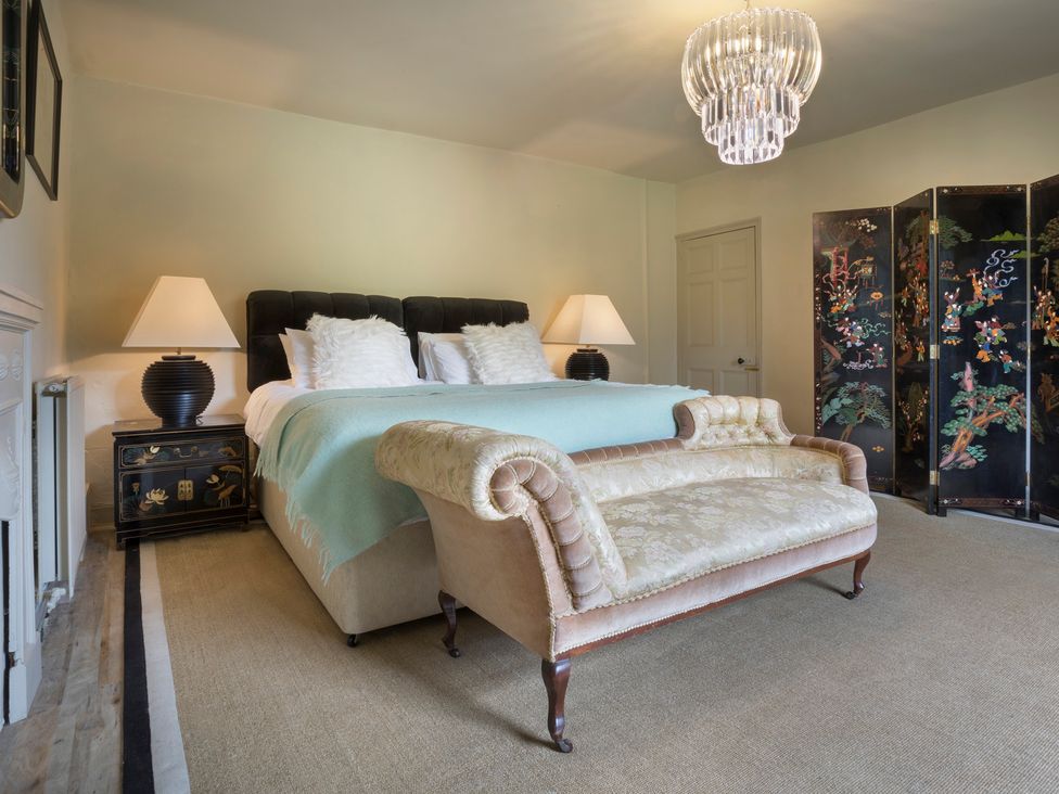 A bedroom with a bed and a sofa at Three Mile House in Carnforth