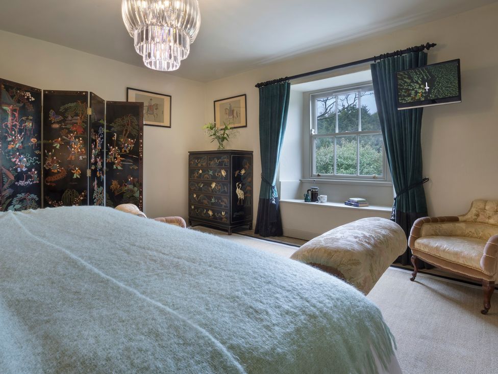 A bedroom with a bed and a cabinet at Three Mile House in Carnforth