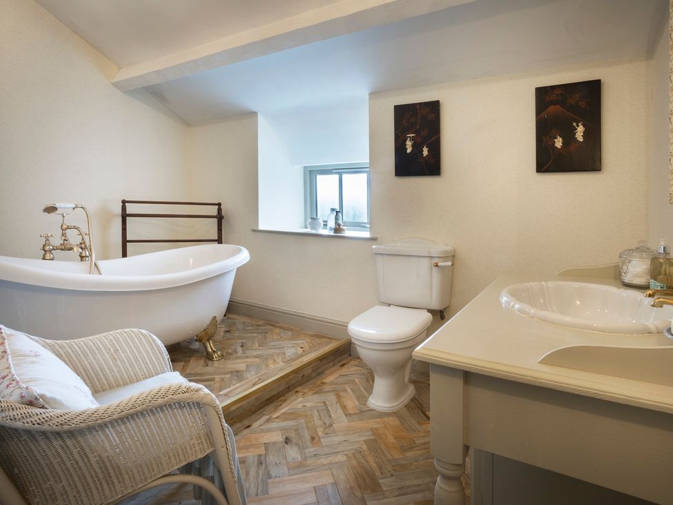 A bathroom with a bathtub, toilet, and sink at Three Mile House in Carnforth