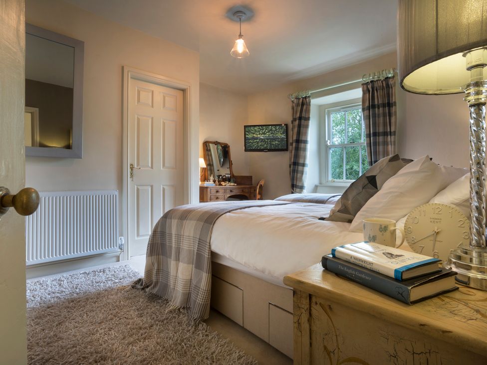 A bedroom with a bed and lamp at Three Mile House in Carnforth