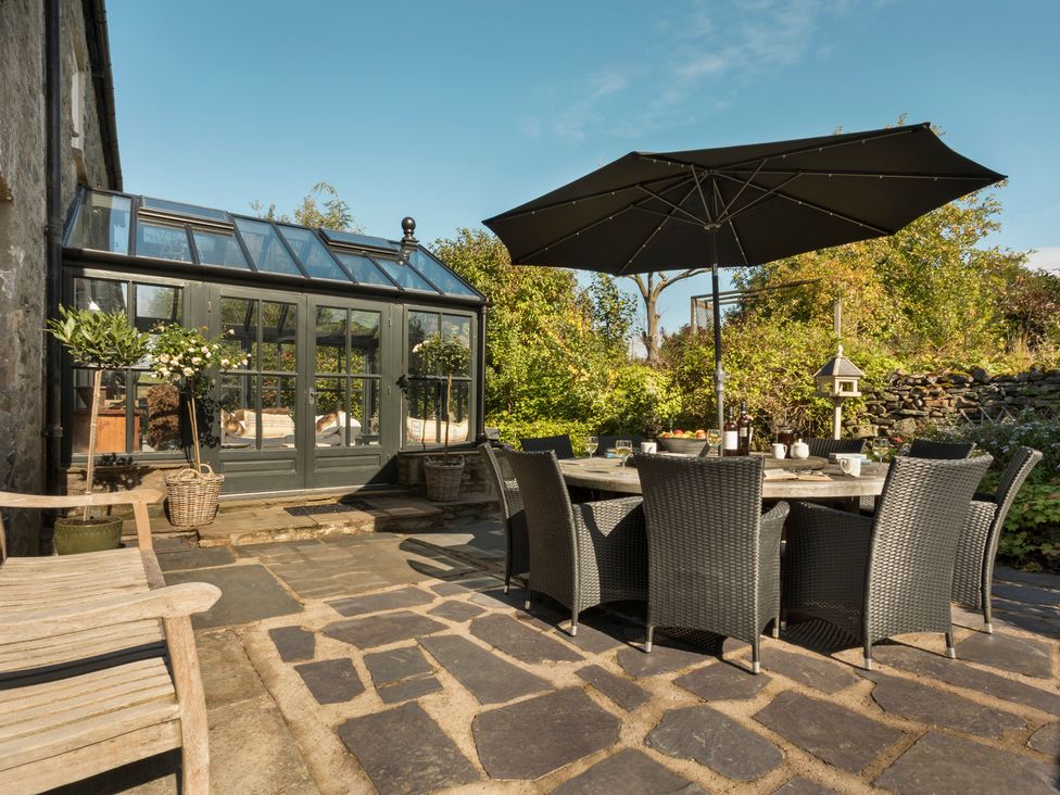 An outdoor dining area with a table and chairs at Three Mile House in Carnforth