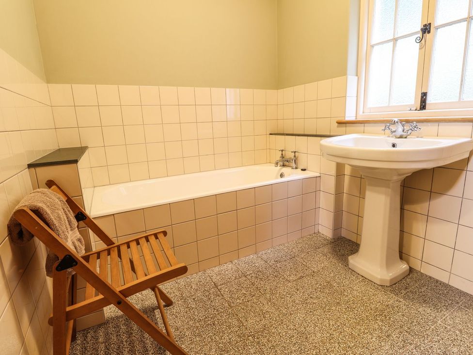A bathroom with a bath tub and wash basin at Llys Gwaun Fishguard