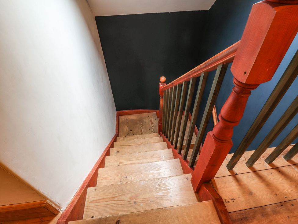 A staircase with wooden steps and a handrail at Llys Gwaun in Fishguard