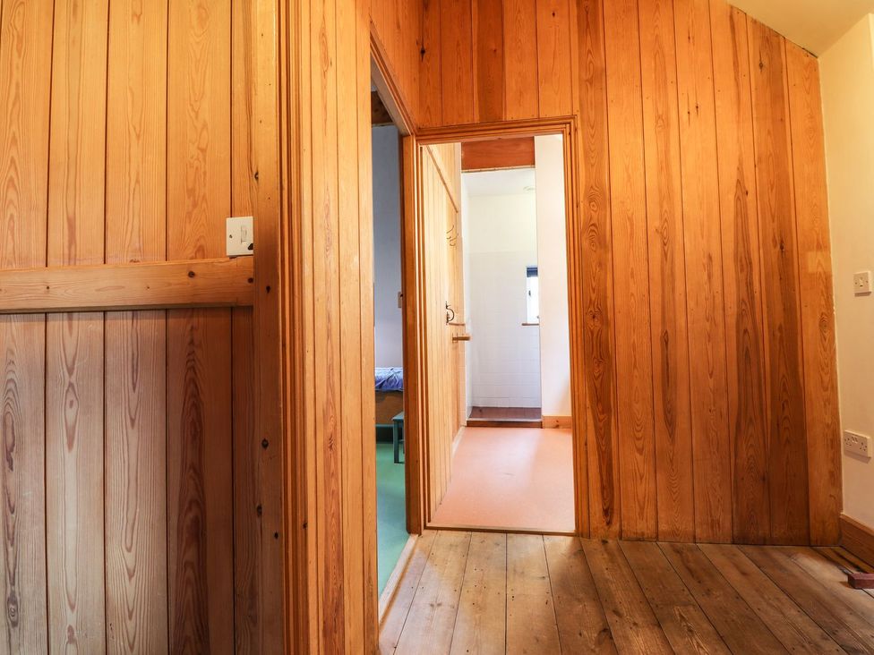 A hallway with wooden walls and doors at Llys Gwaun in Fishguard