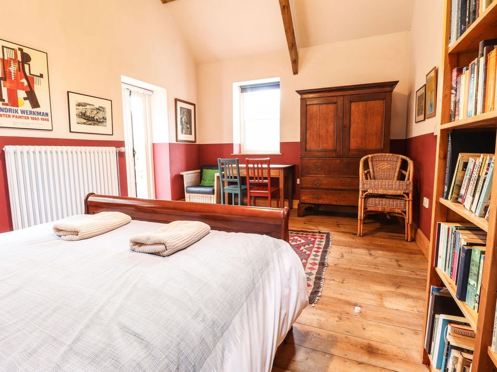 A bedroom with a bed and bookshelf at Llys Gwaun Fishguard