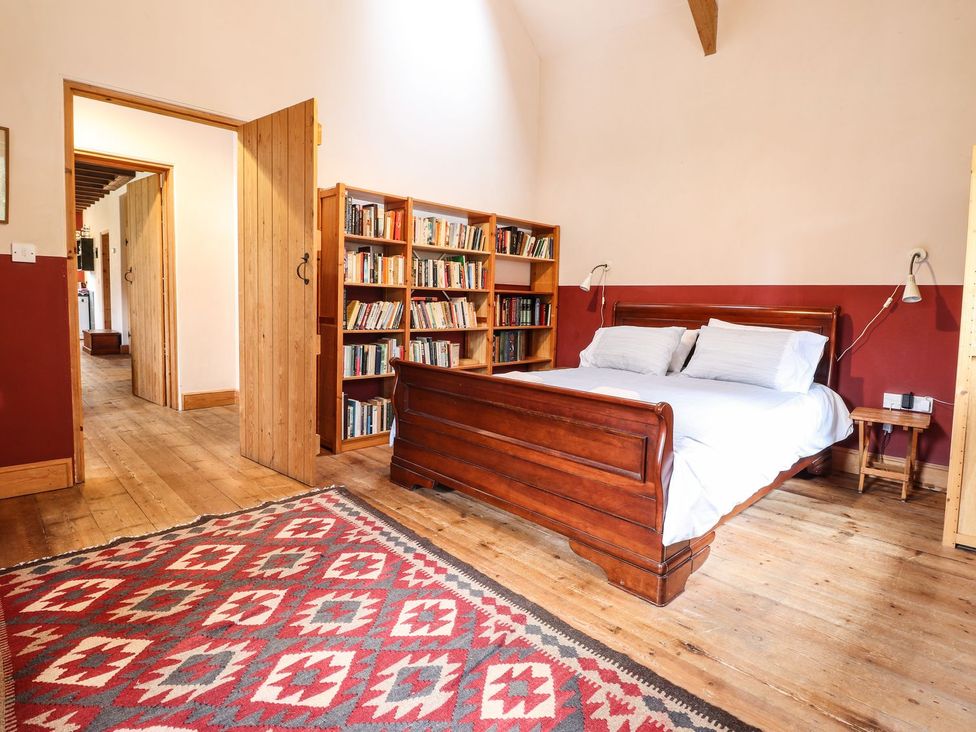 A bedroom with a bed and bookshelf at Llys Gwaun in Fishguard