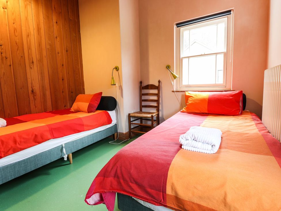 A bedroom with two beds and a chair at Llys Gwaun in Fishguard