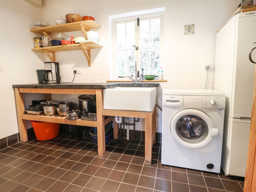 A kitchen with a sink and washing machine at Llys Gwaun in Fishguard