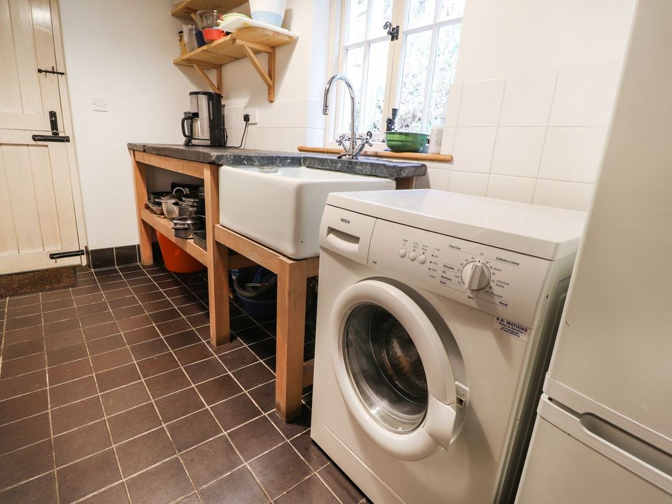 A kitchen with a washing machine and sink at Llys Gwaun in Fishguard