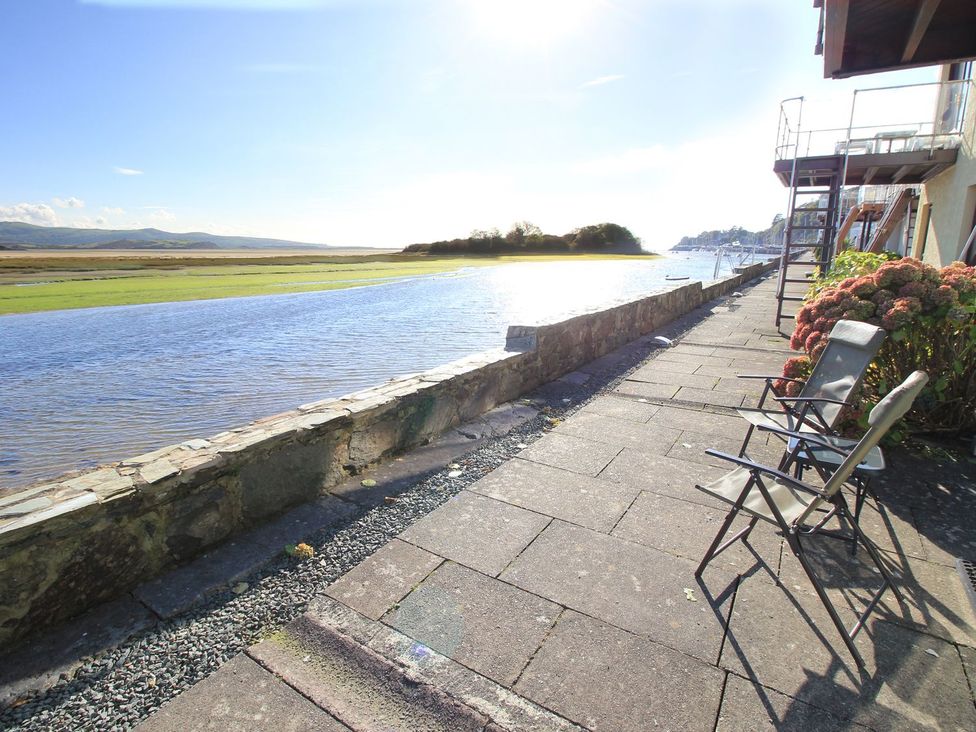 A riverside view with chairs and a pathway at Aldena South Snowdon Wharf Porthmadog