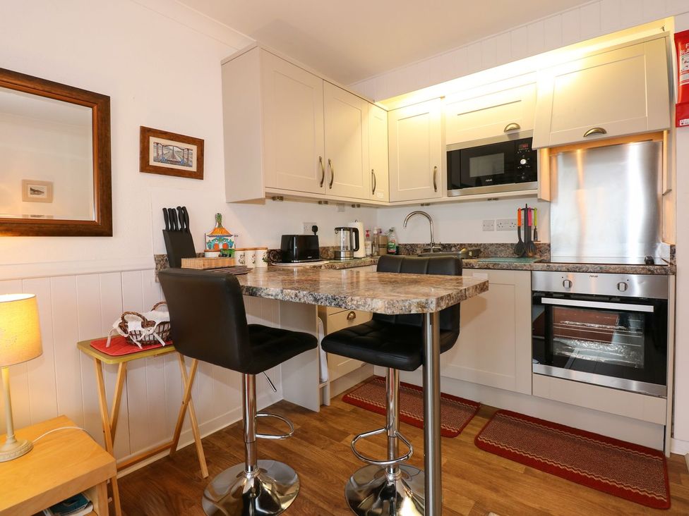 A kitchen with appliances and furniture at Aldena South Snowdon Wharf Porthmadog