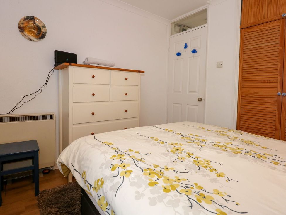 A bedroom with a bed, dresser, and chair at Aldena South Snowdon Wharf, Porthmadog
