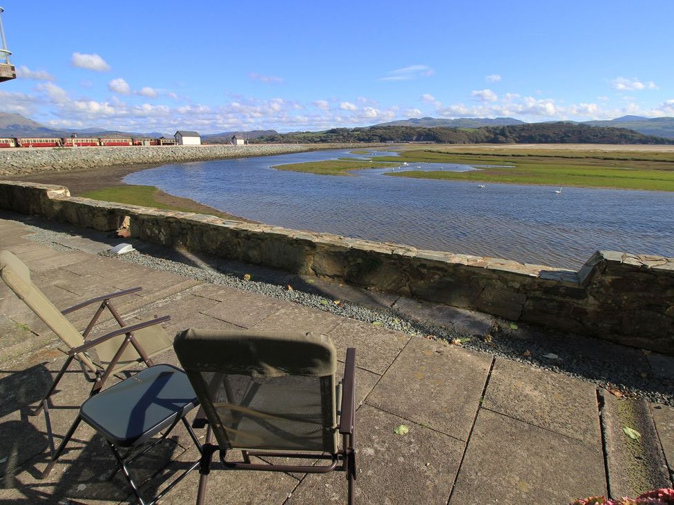 A view of a river with chairs beside it at Aldena South Snowdon Wharf Porthmadog