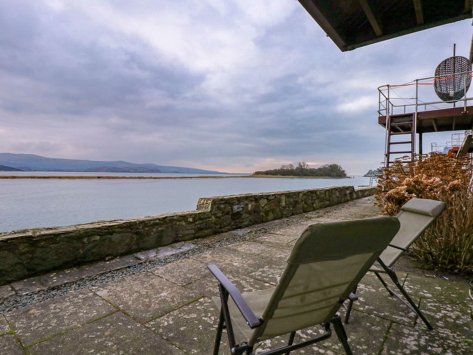 A patio area with chairs and a view of the water at Aldena South Snowdon Wharf Porthmadog