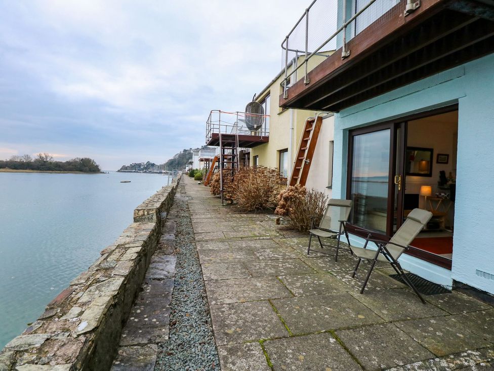 An outdoor pathway by the water with chairs and buildings at Aldena South Snowdon Wharf Porthmadog
