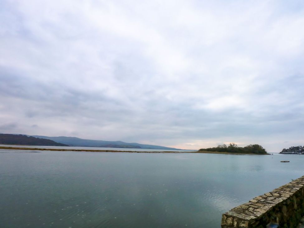 A view of water and mountains with a stone wall at Aldena South Snowdon Wharf in Porthmadog