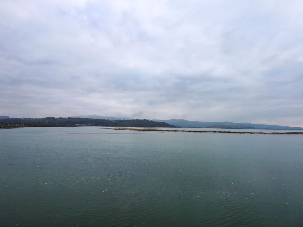 A body of water and land under cloudy skies near Aldena South Snowdon Wharf in Porthmadog