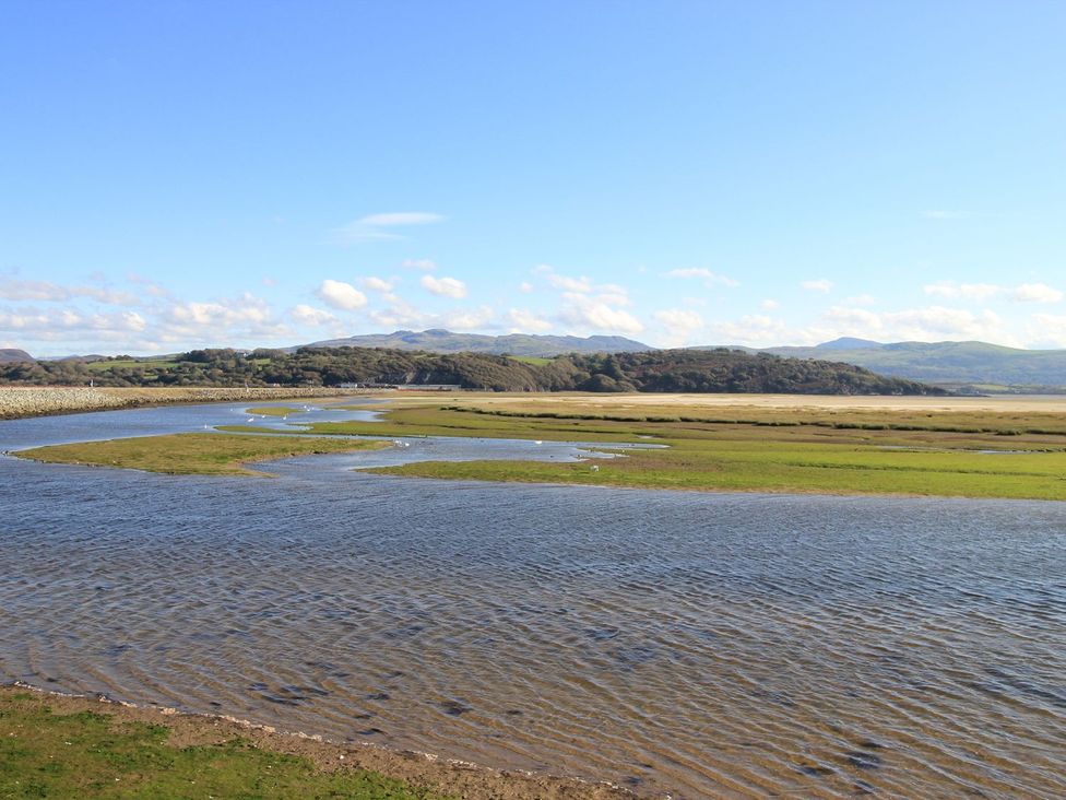 A river winding through grassland with mountains in the background at Aldena South Snowdon Wharf Porthmadog