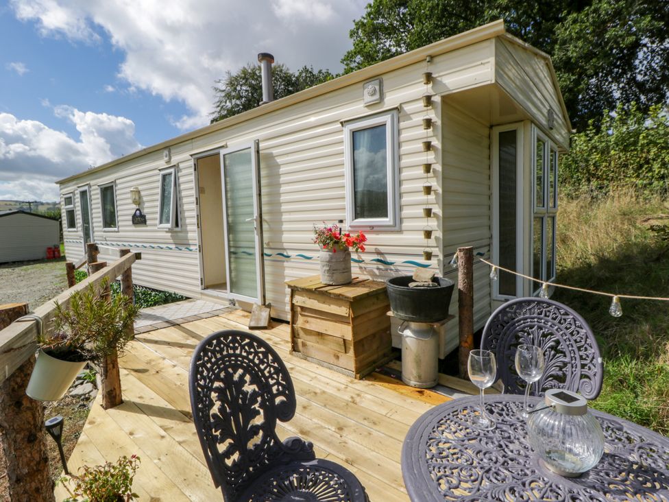 A mobile home with a deck and outdoor seating at Leven in Lampeter
