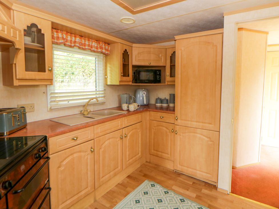 A kitchen with cabinets and a sink at Leven in Lampeter