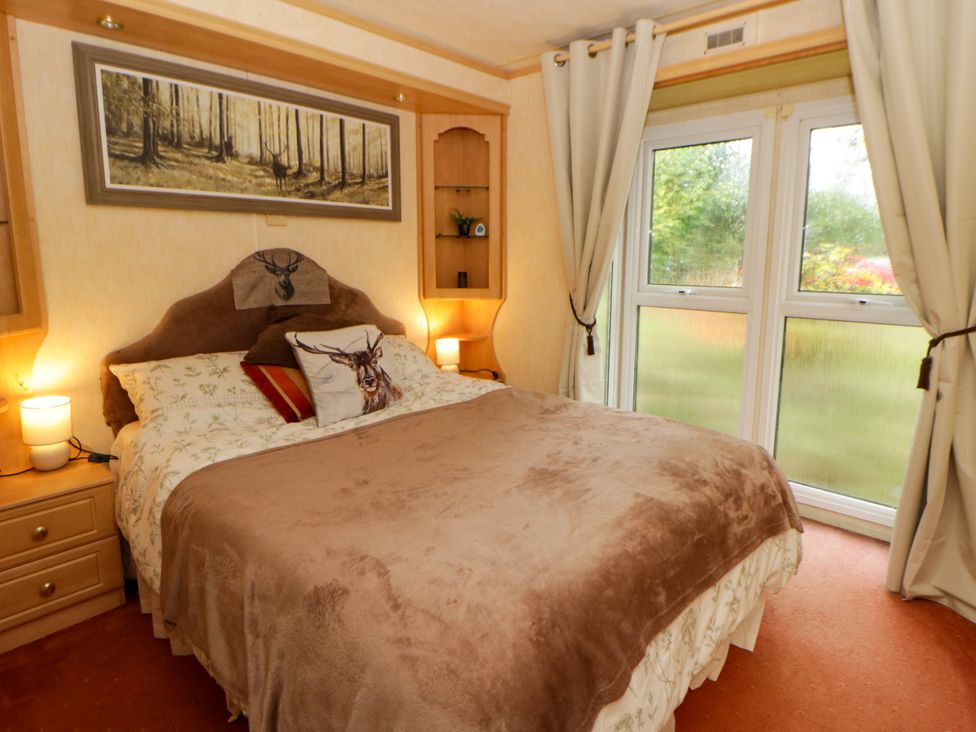 A bedroom with a bed and nightstand at Leven in Lampeter