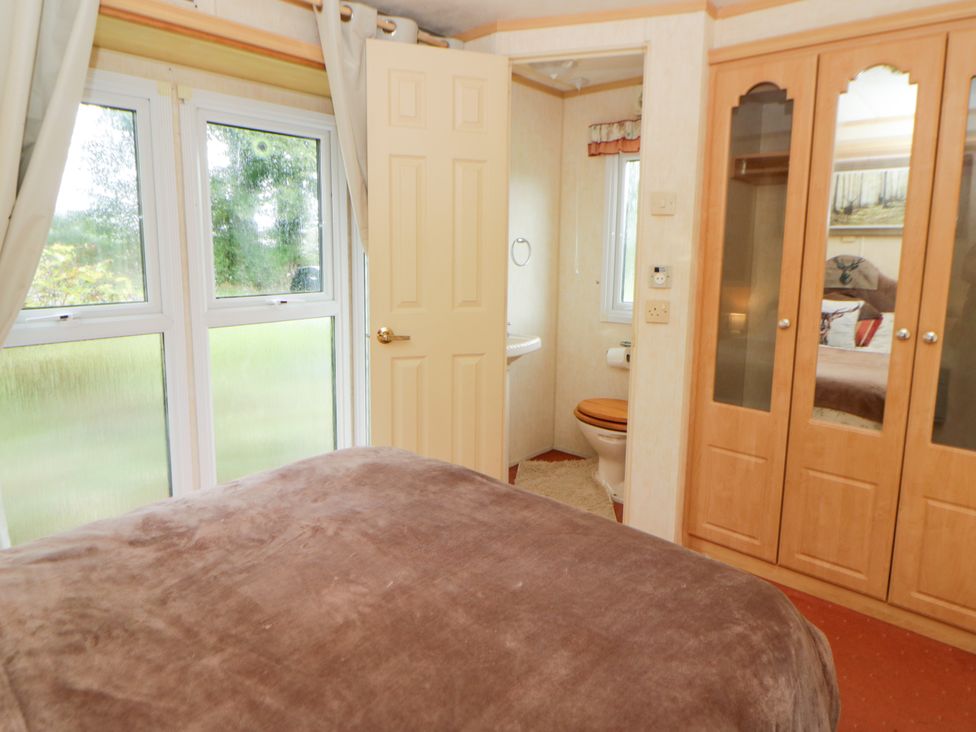 A bedroom with a bed and toilet in the corner at Leven in Lampeter