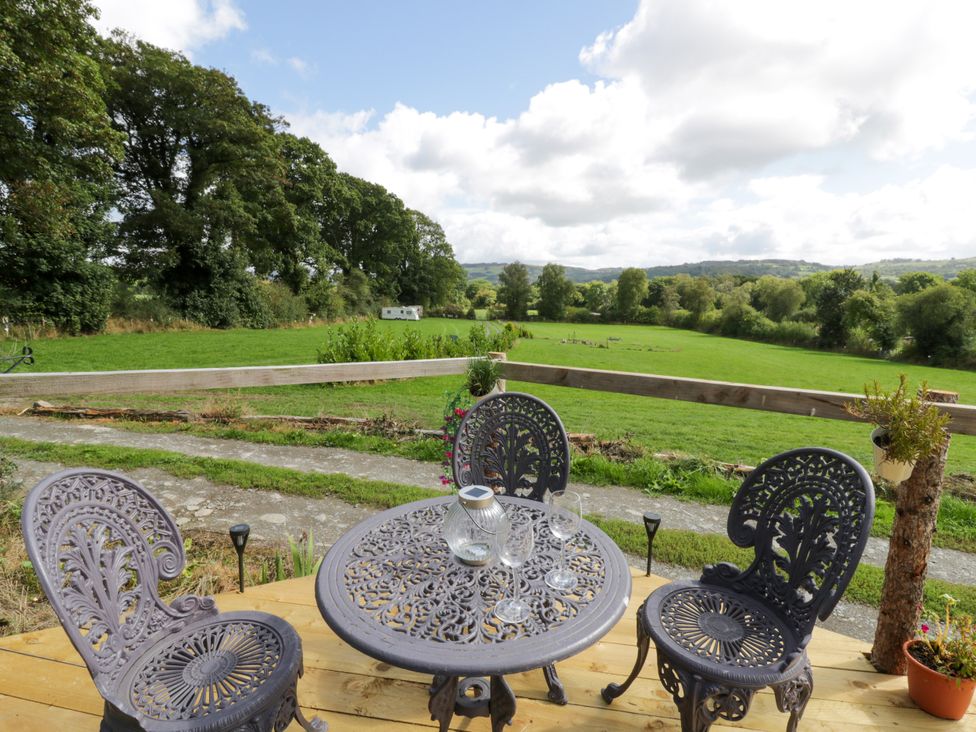 An outdoor seating area with a table and chairs at Leven in Lampeter