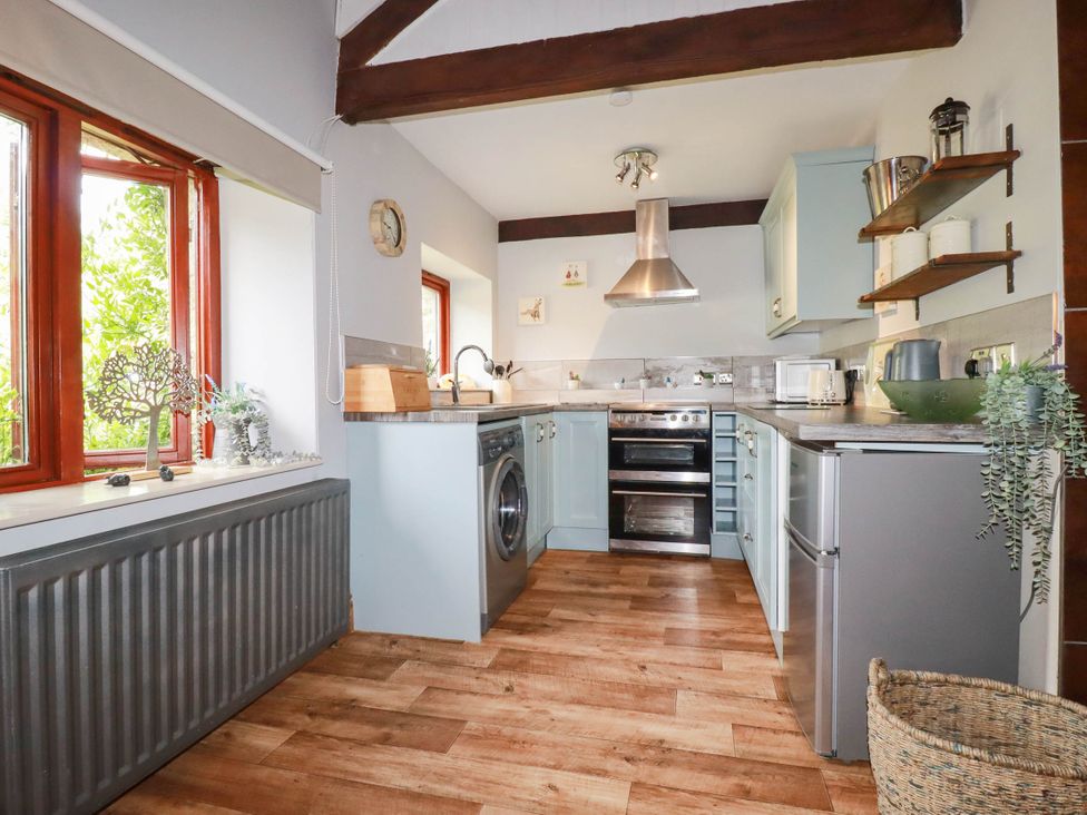 A kitchen with appliances and wooden flooring at Skylark in Liskeard