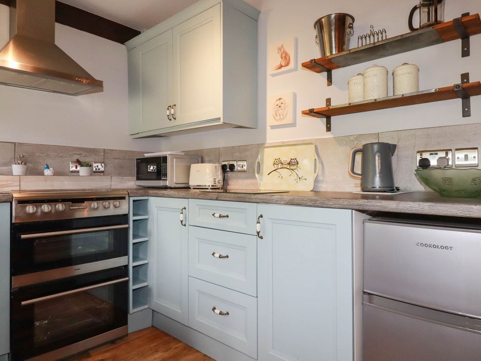 A kitchen with appliances and shelves at Skylark in Liskeard