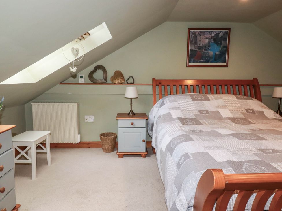 A bedroom with a bed and nightstand at Skylark in Liskeard