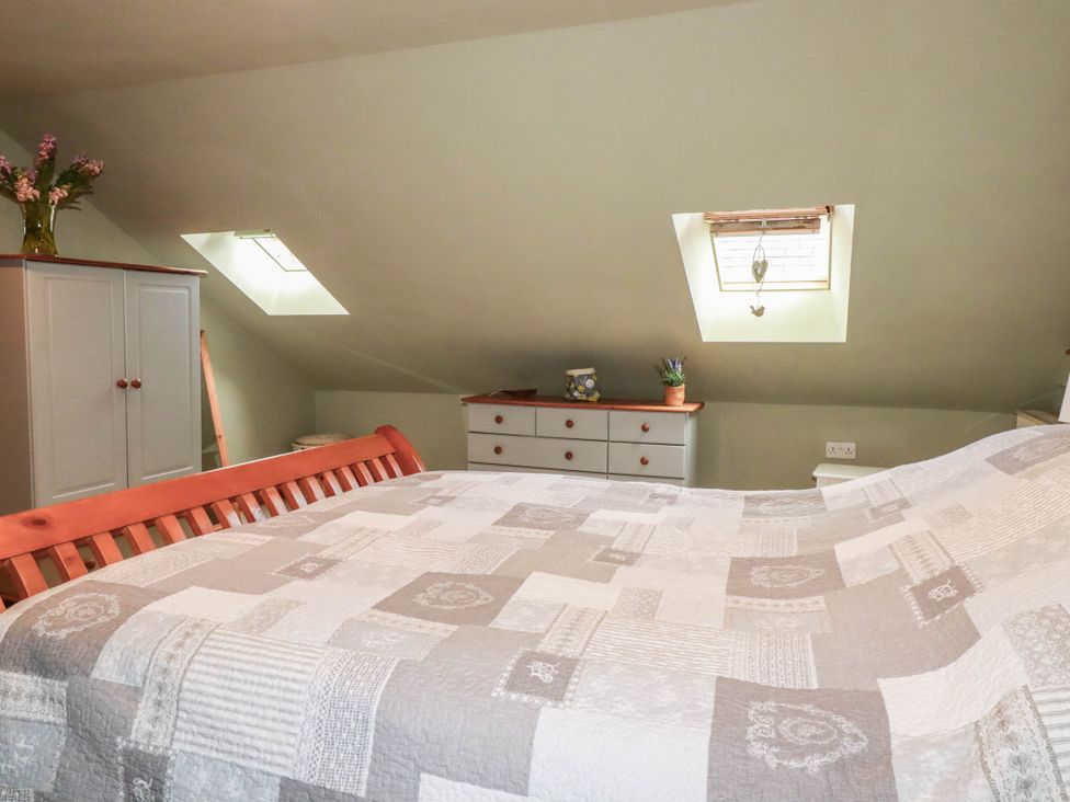 A bedroom with a bed and a wardrobe at Skylark in Liskeard