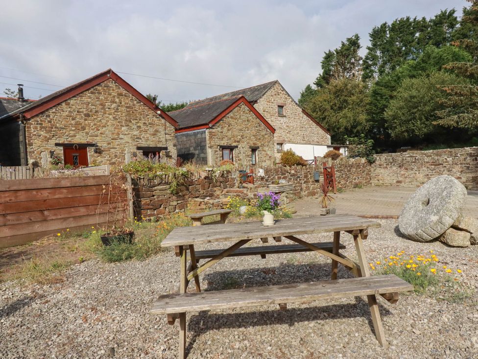 A garden with a table and flowers at Skylark in Liskeard