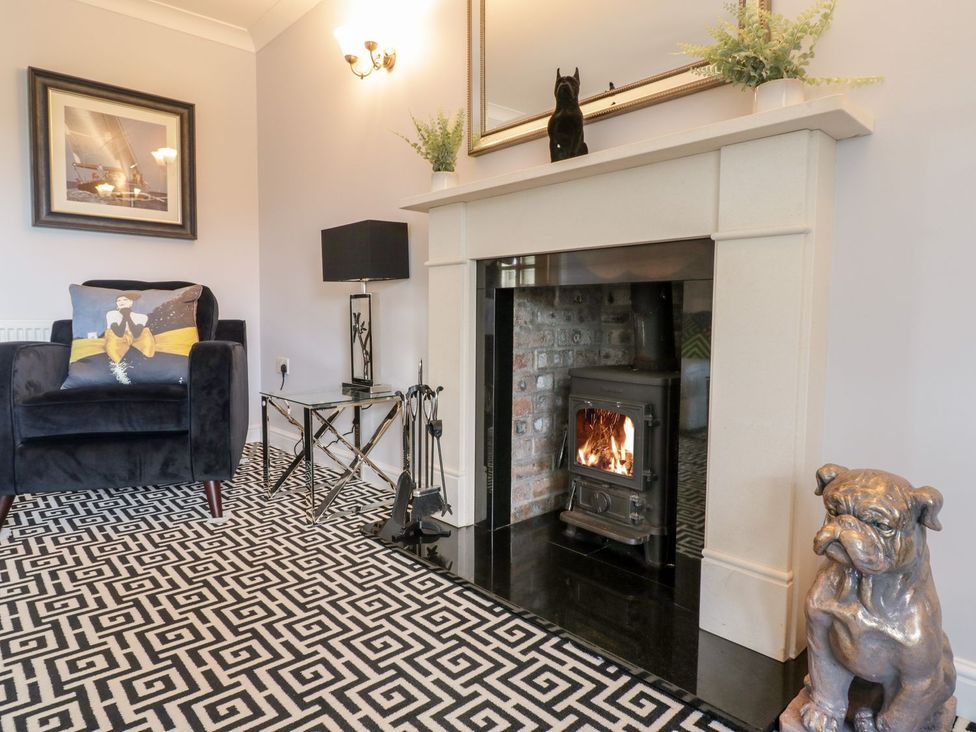 A living room with a fireplace and an armchair at Ger Y Mor in Cemaes Bay